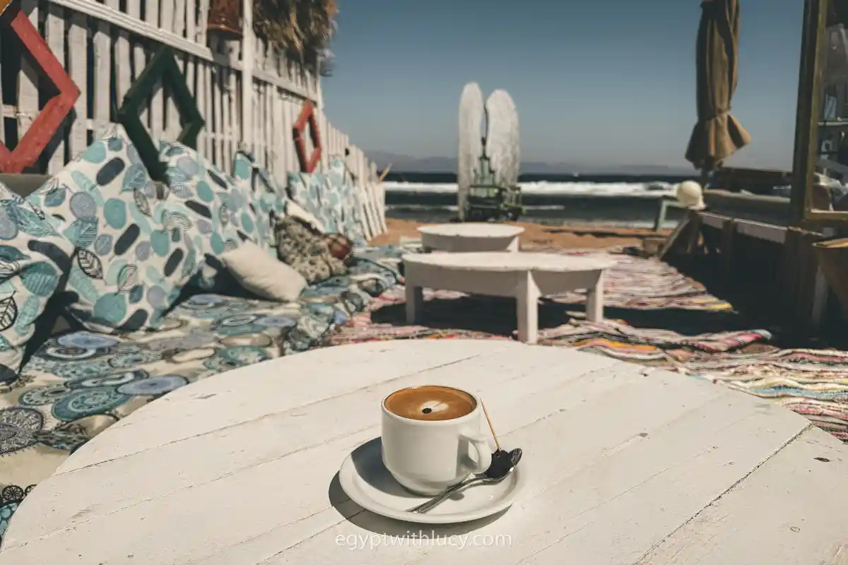 A cup rests on a white table at Flat White cafe.