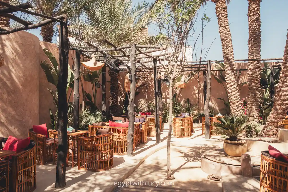 Bamboo chairs and wooden tables sit under a pergola at Shanti Cafe.