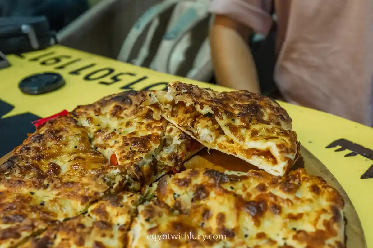 alexandrian-style-hawawshi Baked Alexandrian-style hawawshi stuffed with meat and cheese, sliced on a wooden board.