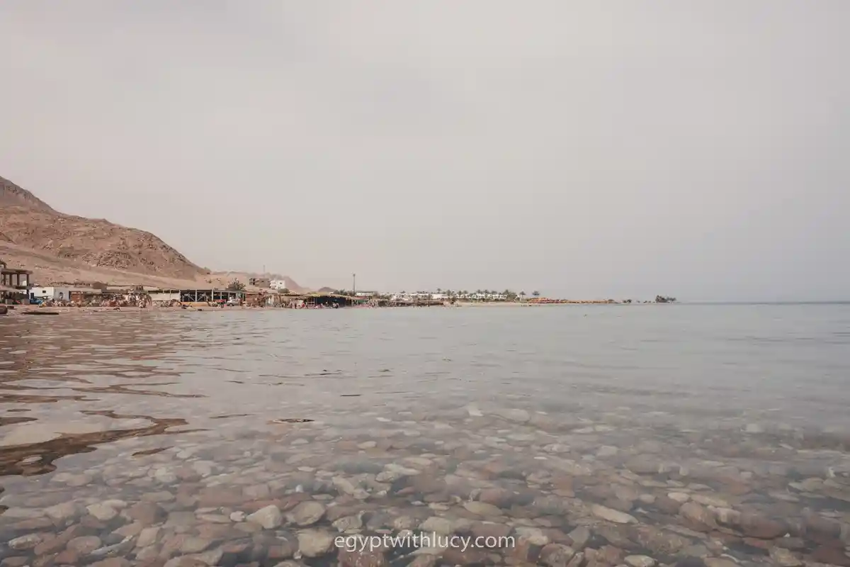 Shallow, clear sea water showing smooth, colorful pebbles on the seabed at Three Pools.
