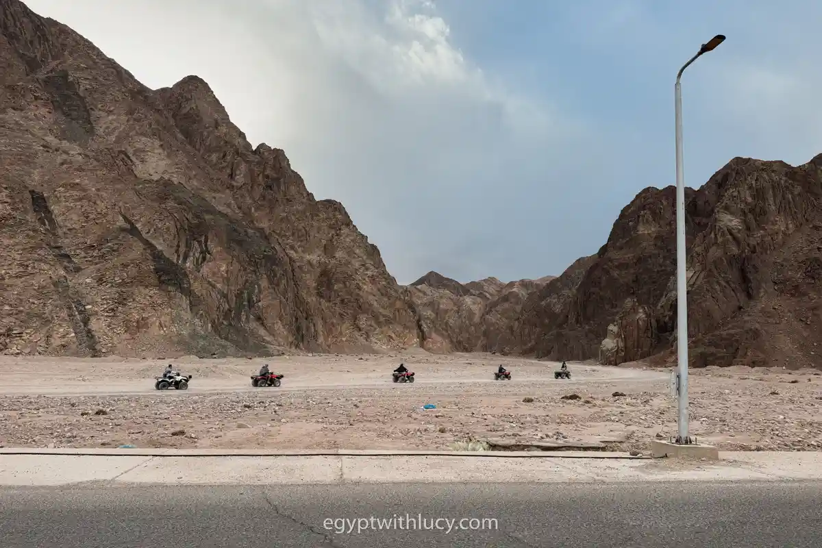 three-pools-quad-bikers Five quad bikes driving in a line towards the entrance to Wadi Gnai near Three Pools.